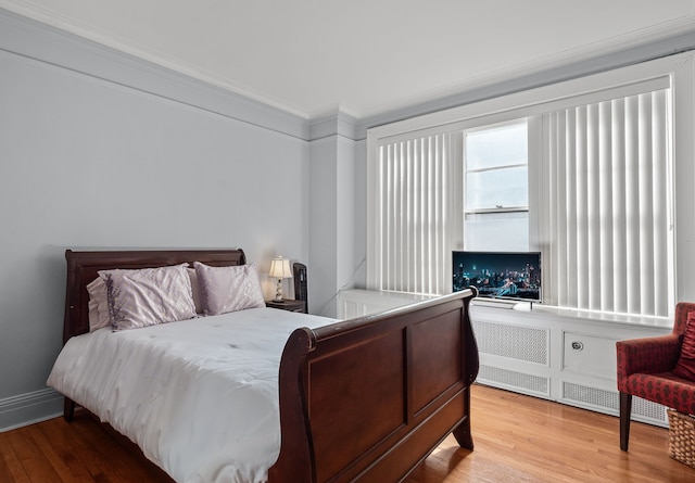 bedroom featuring crown molding and wood finished floors