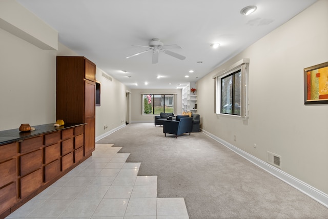 carpeted living room with ceiling fan