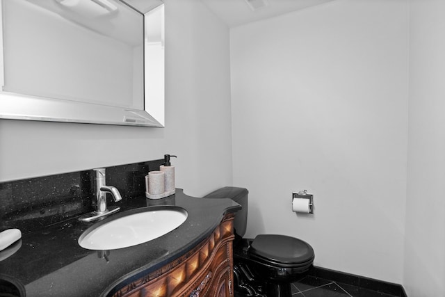 bathroom featuring tile patterned flooring, vanity, and toilet