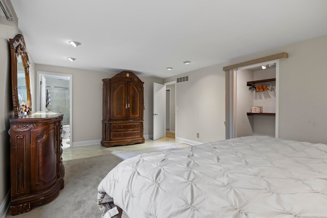 bedroom featuring a spacious closet, ensuite bath, and a closet