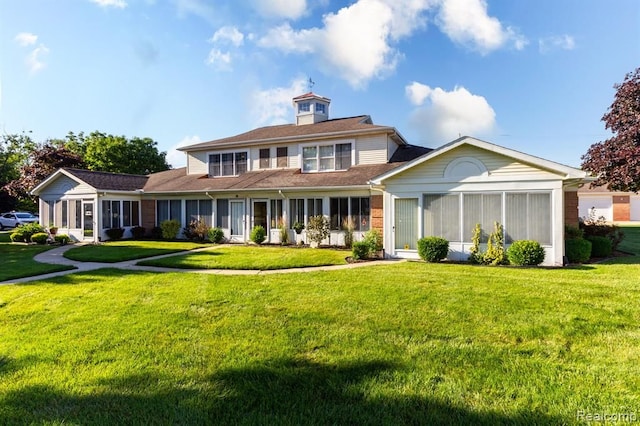 view of front of property with a front lawn and a sunroom