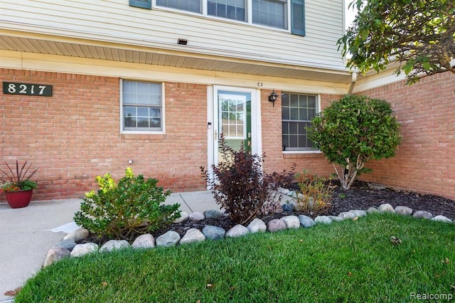 doorway to property with a lawn