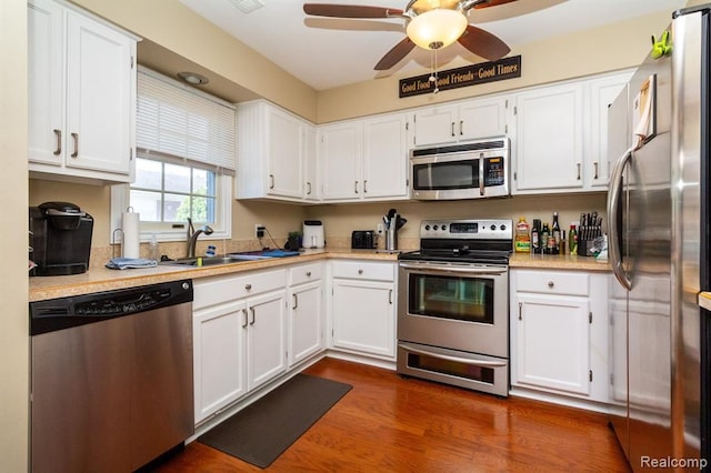 kitchen featuring white cabinets, appliances with stainless steel finishes, dark hardwood / wood-style floors, and sink