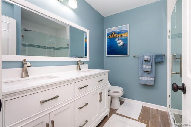 bathroom featuring vanity, toilet, and a shower with door