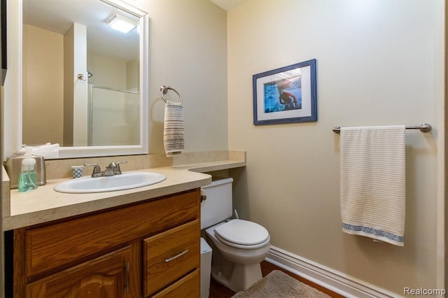 bathroom with a shower with door, vanity, and toilet