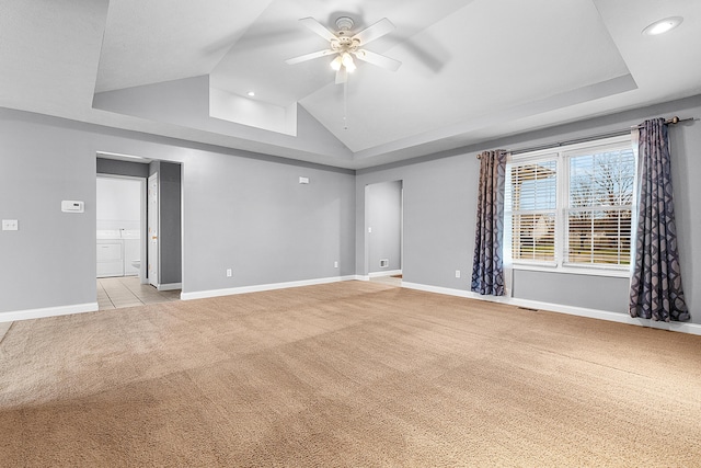 spare room featuring a raised ceiling, ceiling fan, high vaulted ceiling, and light colored carpet