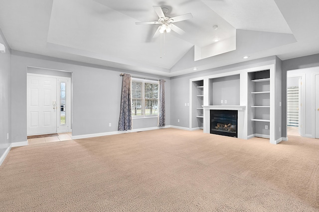 unfurnished living room with built in shelves, ceiling fan, light colored carpet, and lofted ceiling