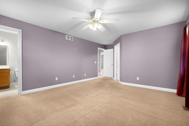 unfurnished bedroom featuring connected bathroom, ceiling fan, and light carpet