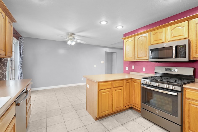 kitchen featuring kitchen peninsula, light tile patterned floors, stainless steel appliances, and ceiling fan