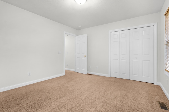 unfurnished bedroom with carpet flooring and a closet