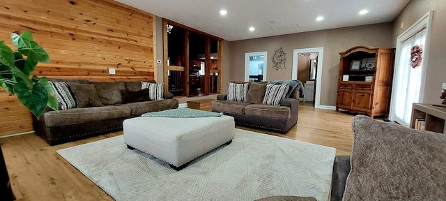 living room featuring wooden walls and light hardwood / wood-style floors