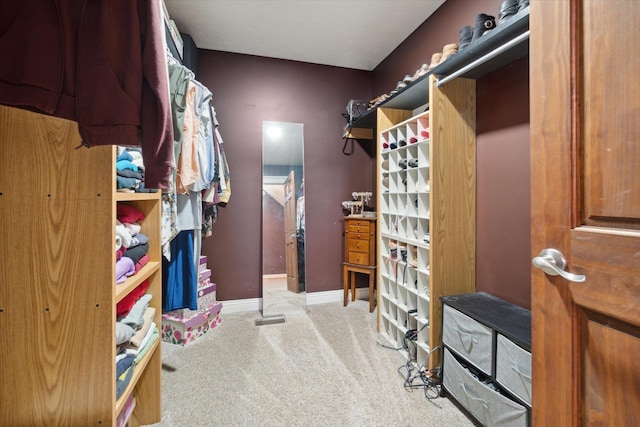 walk in closet featuring light colored carpet