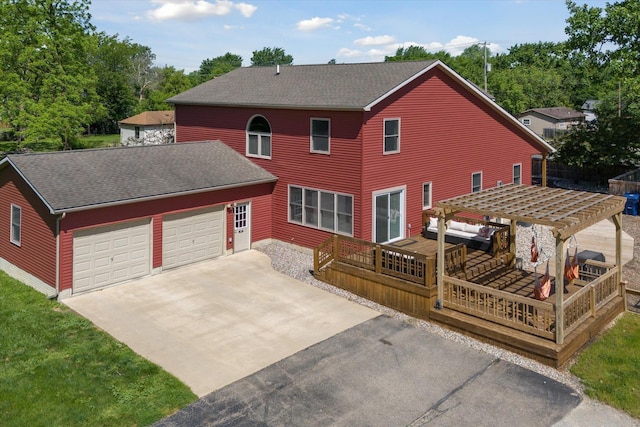 back of property with a pergola, a garage, and a wooden deck