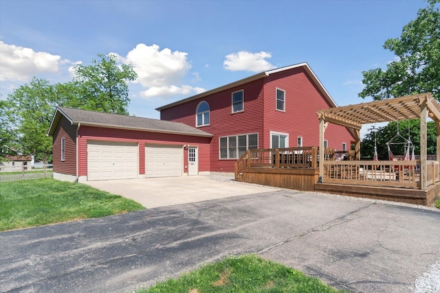 view of front of home featuring a pergola, a garage, a deck, and a front yard