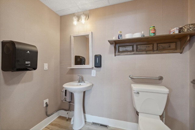 bathroom with hardwood / wood-style flooring and toilet