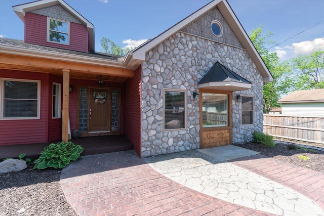 210 E Mcneil St, Corunna, MI 48817 - view of front of home with stone siding, fence, and covered porch