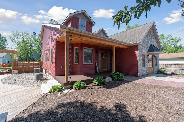 view of front of property with a wooden deck, cooling unit, and a patio