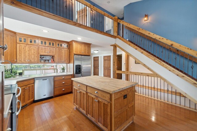 210 E Mcneil St, Corunna, MI 48817 - kitchen with stainless steel appliances, brown cabinets, a sink, light wood finished floors, and wood counters