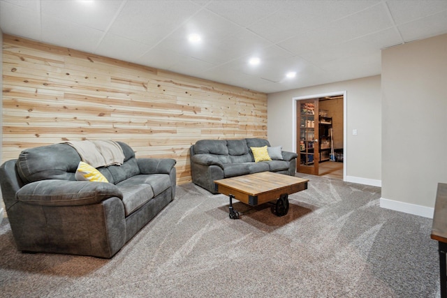 carpeted living room with wood walls