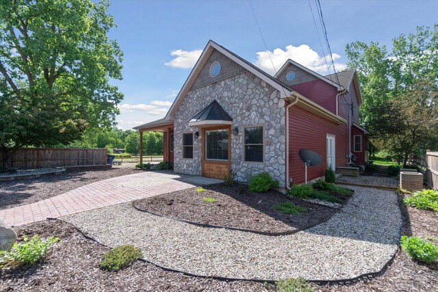 210 E Mcneil St, Corunna, MI 48817 - rear view of property with stone siding, a patio area, and fence