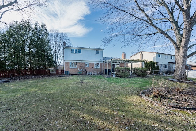 rear view of property featuring a lawn and a pergola