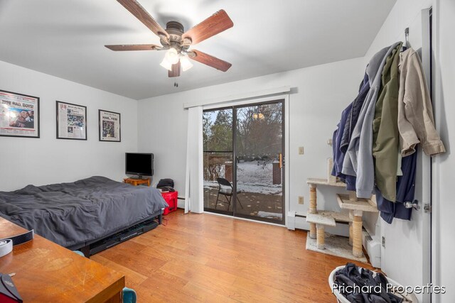 bedroom featuring access to exterior, ceiling fan, light hardwood / wood-style floors, and a baseboard radiator