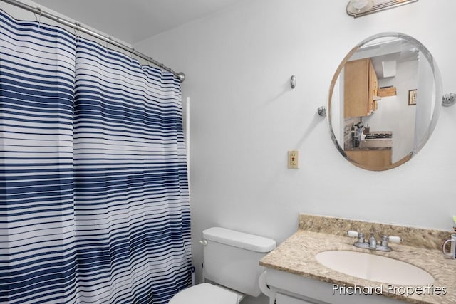 bathroom with a shower with shower curtain, vanity, and toilet