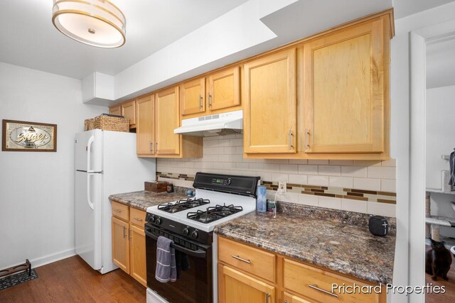 kitchen with backsplash, dark stone countertops, light brown cabinets, and white appliances