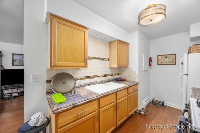 kitchen featuring stove, tasteful backsplash, sink, white fridge, and dark hardwood / wood-style floors