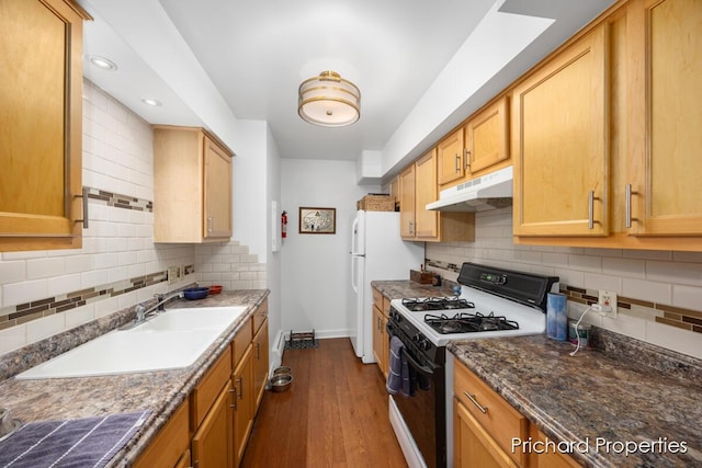 kitchen featuring dark stone countertops, decorative backsplash, dark hardwood / wood-style floors, and white appliances