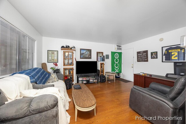 living room featuring an AC wall unit and hardwood / wood-style flooring