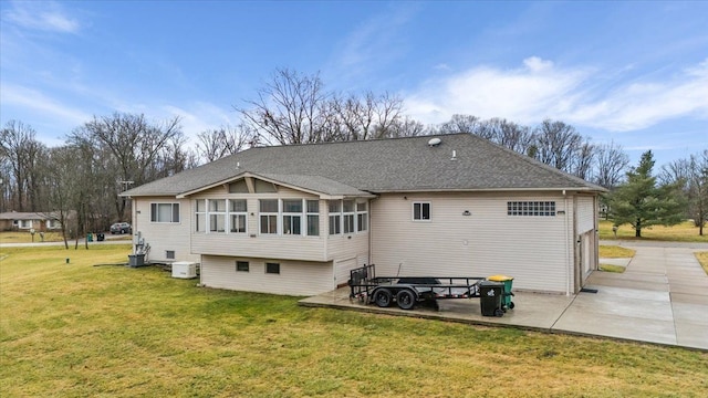 rear view of house with a sunroom, central AC unit, a patio area, and a yard