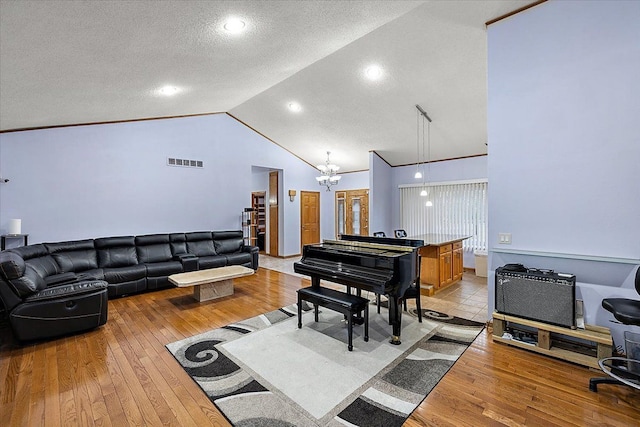 living room featuring light hardwood / wood-style flooring, a notable chandelier, crown molding, a textured ceiling, and lofted ceiling