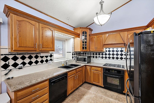 kitchen featuring black appliances, sink, decorative backsplash, decorative light fixtures, and custom range hood