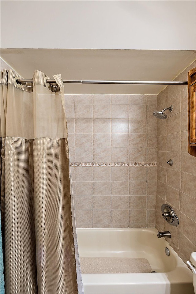 bathroom with toilet and shower / bath combo with shower curtain