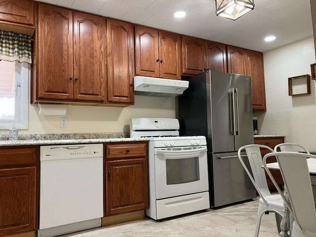 kitchen featuring light stone counters and white appliances