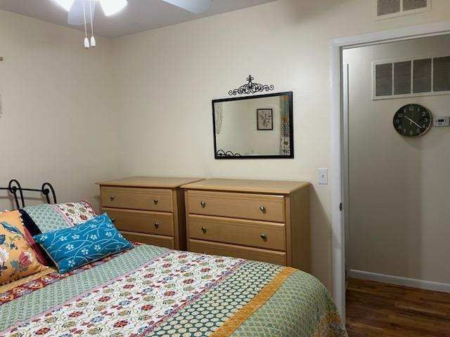 bedroom with ceiling fan and dark wood-type flooring