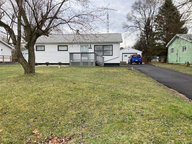 view of front of property featuring a garage, an outbuilding, and a front lawn