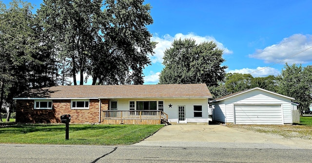 ranch-style home featuring covered porch, a garage, an outdoor structure, and a front lawn