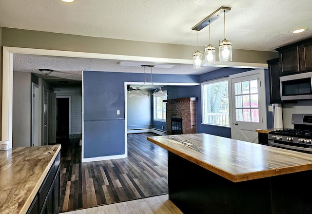 kitchen featuring butcher block countertops, hanging light fixtures, and dark wood-type flooring