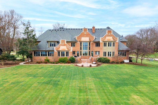 back of house featuring a lawn and a patio