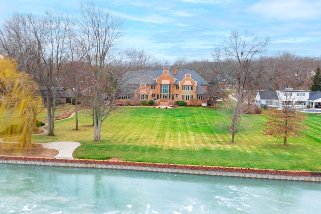 back of house with a yard and a water view