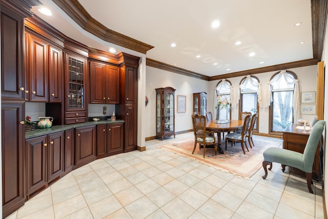 kitchen featuring light tile patterned floors, dark stone counters, and ornamental molding