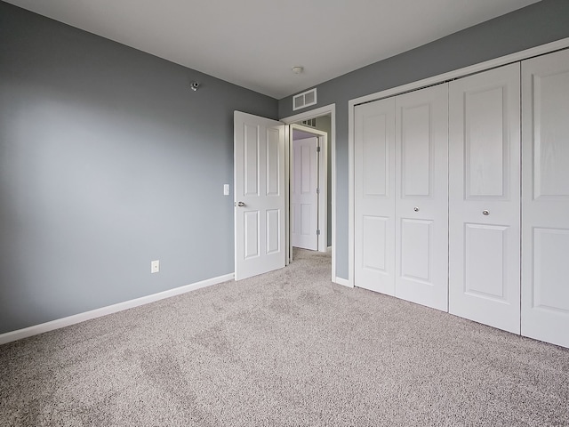 unfurnished bedroom featuring carpet flooring and a closet