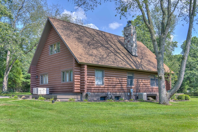 view of side of property featuring a lawn and central air condition unit