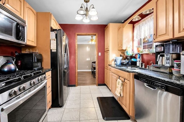 kitchen featuring sink, appliances with stainless steel finishes, and dark stone counters