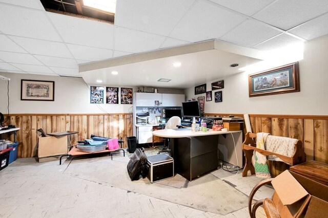 home office featuring a paneled ceiling and wood walls