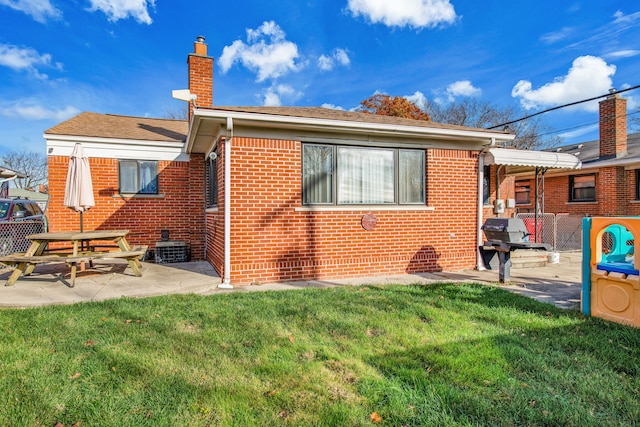 back of property featuring a yard and a patio