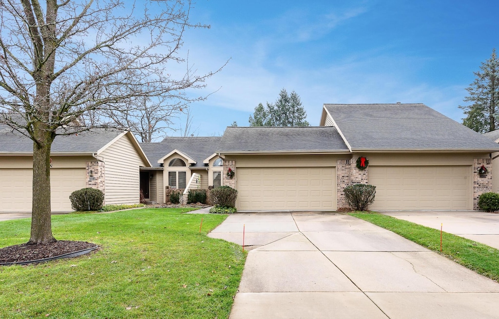 ranch-style house featuring a front yard and a garage