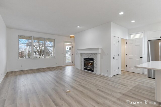 unfurnished living room featuring a fireplace and light hardwood / wood-style flooring